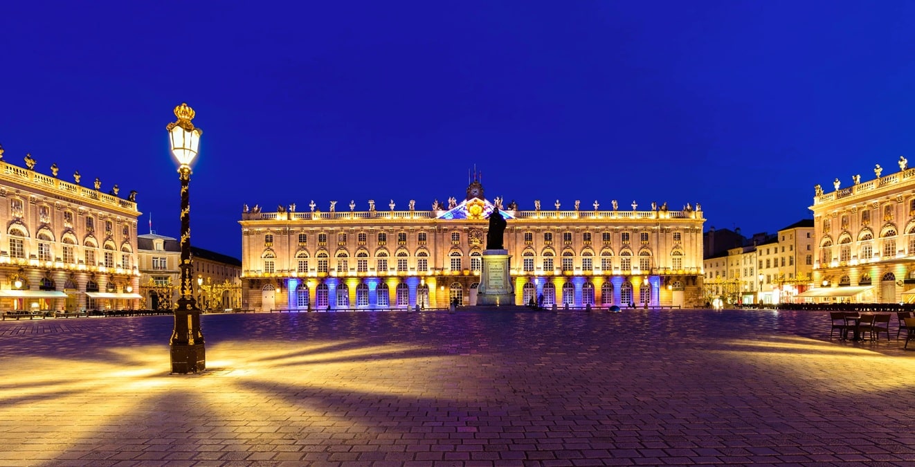 La place Stanislas illuminée à l’heure bleue, ensemble classique du XVIIIe siècle conçu par l’architecte Emmanuel Héré et inscrit au patrimoine mondial de l’UNESCO, avec l’hôtel de ville, la statue de Stanislas Leszczyński, ses pavillons à balustrades et un réverbère aux ornements dorés, au cœur de Nancy, dans le département de Meurthe-et-Moselle, en région Grand Est. La place Stanislas illuminée à l’heure bleue, ensemble classique du XVIIIe siècle conçu par l’architecte Emmanuel Héré et inscrit au patrimoine mondial de l’UNESCO, avec l’hôtel de ville, la statue de Stanislas Leszczyński, ses pavillons à balustrades et un réverbère aux ornements dorés, au cœur de Nancy, dans le département de Meurthe-et-Moselle, en région Grand Est.