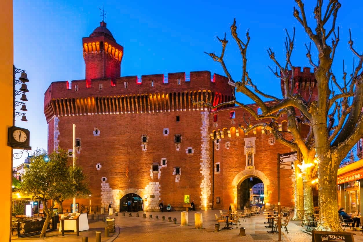 Le Castillet illuminé à l’heure bleue, ancienne porte fortifiée en brique du XIVe siècle classée monument historique, avec son couronnement de créneaux, sa haute tourelle et la porte Notre-Dame, qui abrite aujourd’hui la Casa Pairal, musée catalan des arts et traditions populaires, au cœur de Perpignan, dans le département des Pyrénées-Orientales, en région Occitanie. Le Castillet illuminé à l’heure bleue, ancienne porte fortifiée en brique du XIVe siècle classée monument historique, avec son couronnement de créneaux, sa haute tourelle et la porte Notre-Dame, qui abrite aujourd’hui la Casa Pairal, musée catalan des arts et traditions populaires, au cœur de Perpignan, dans le département des Pyrénées-Orientales, en région Occitanie.