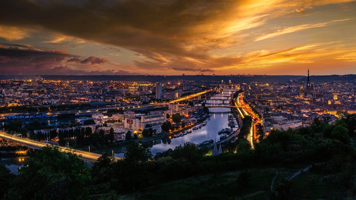 Panorama de Rouen au coucher du soleil depuis la côte Sainte-Catherine, avec la Seine, ses ponts et l’île Lacroix, la flèche en fonte de la cathédrale Notre-Dame, la plus haute de France, et la tour illuminée de l’abbatiale Saint-Ouen, dans le département de la Seine-Maritime, en région Normandie. Panorama de Rouen au coucher du soleil depuis la côte Sainte-Catherine, avec la Seine, ses ponts et l’île Lacroix, la flèche en fonte de la cathédrale Notre-Dame, la plus haute de France, et la tour illuminée de l’abbatiale Saint-Ouen, dans le département de la Seine-Maritime, en région Normandie.